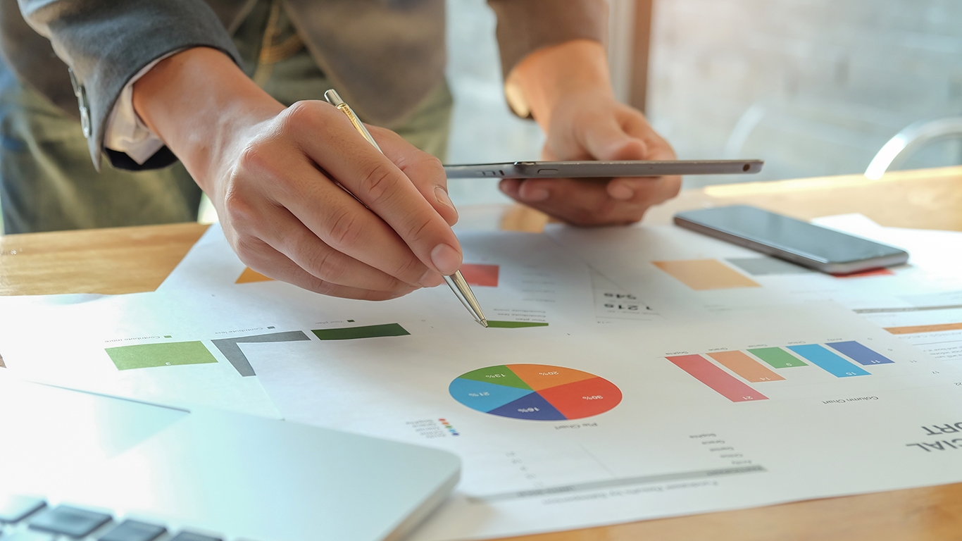 man hand holding pen pointing to graph on desk bus 2024 12 06 15 20 23 utc | Bogart Wealth