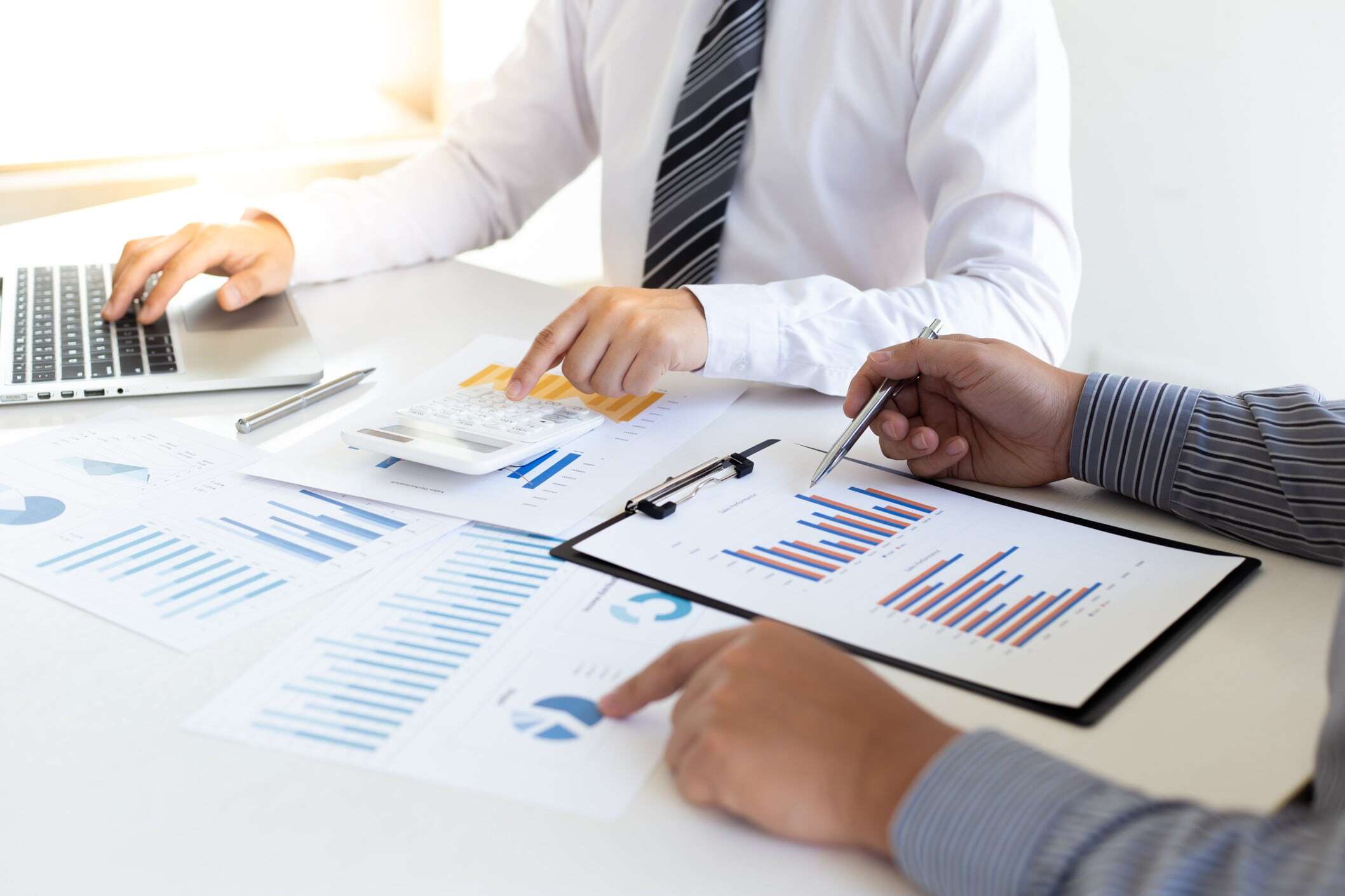 A financial team meeting and looking at graphs working on Tax Optimization.