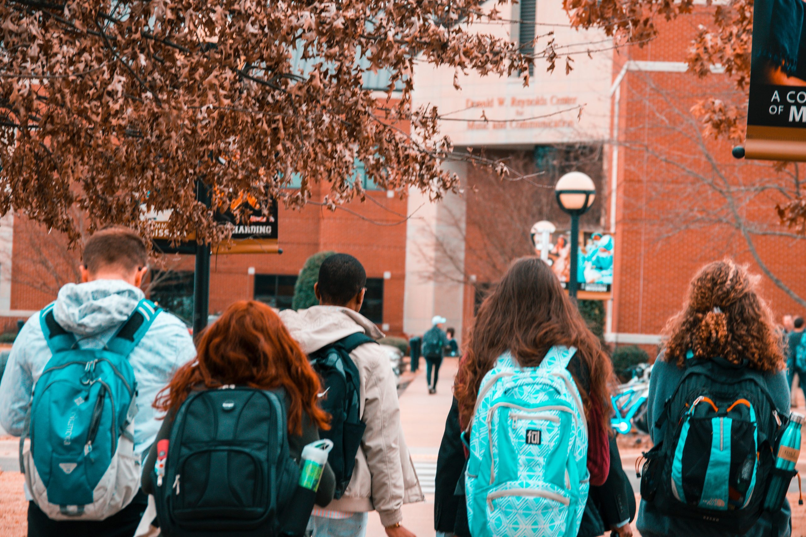 Group of college students walking on campus with backpacks